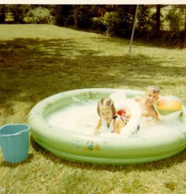 Young boy and girl playing in swimming pool in the late 1960's.