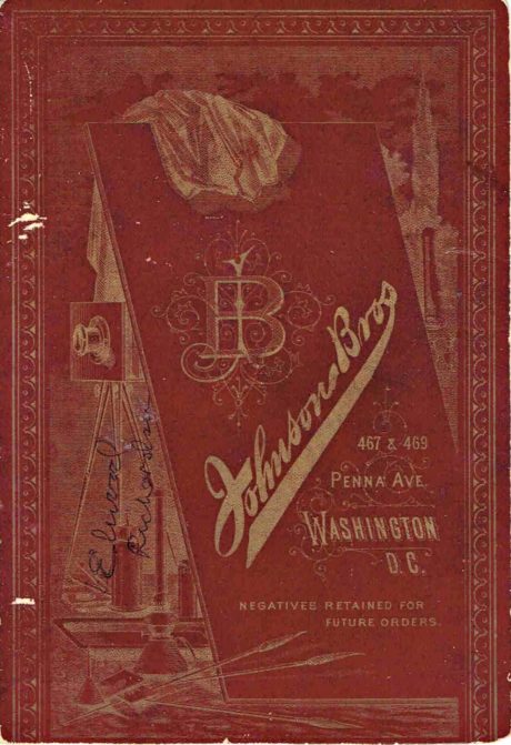 Example of photographer's mark on cabinet card with burgundy background and gold markings and lettering.