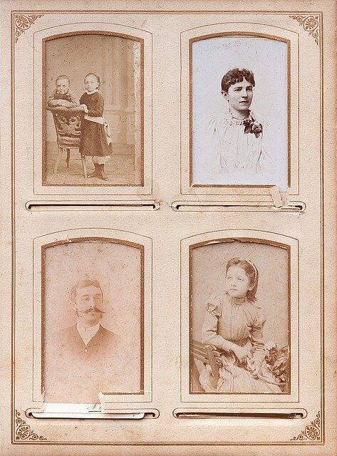 Vintage photo album with 4 photographs in sepia toned. 2 photos of young girls, one of a mother and one of a man with moustache.