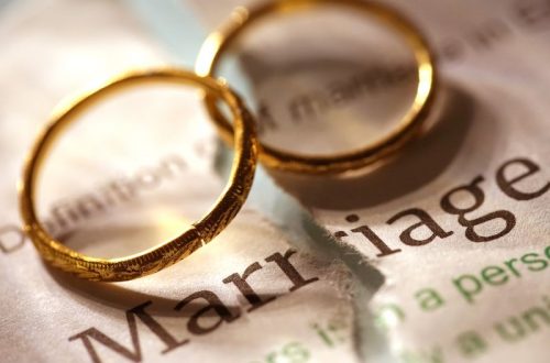 Wedding rings on top of a marriage record