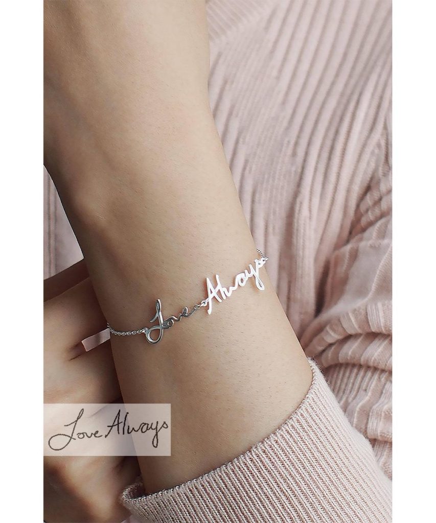 Silver handwritten bracelet reading "Love Always" on a woman's arm