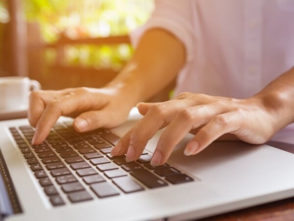 close up of hands on laptop keyboard