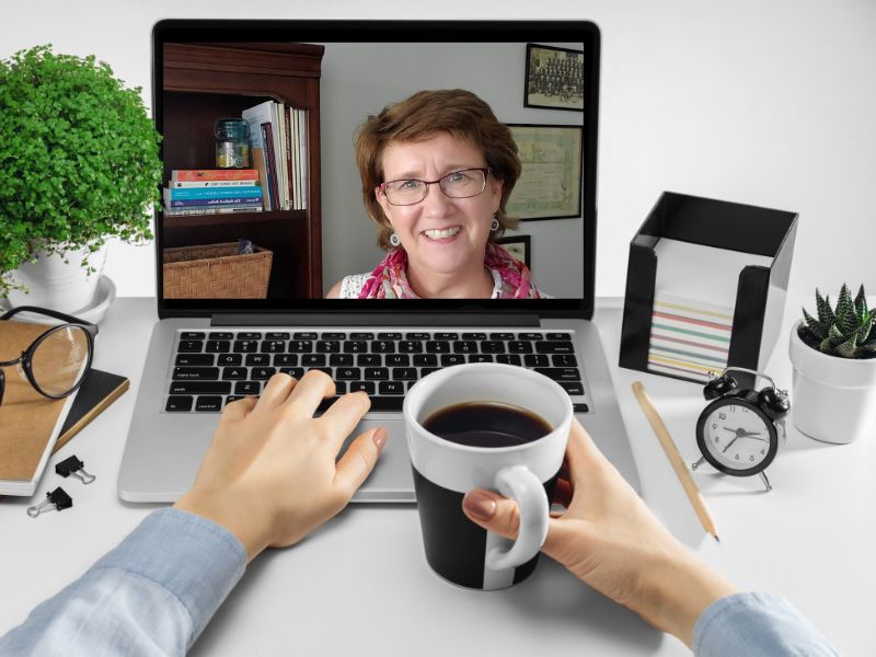Lisa Lisson on a laptop with viewer's hands with coffee cup on keyboard