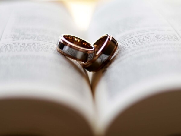 silver and gold wedding bands on a Bible