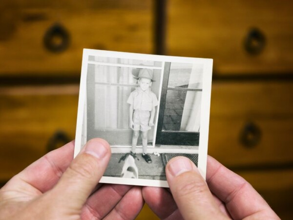hands holding black and white photo of little boy