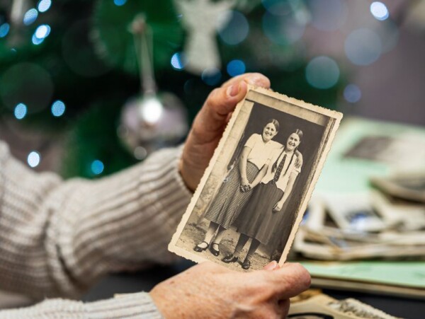 woman's hands holding old black and white photo of 2 women
