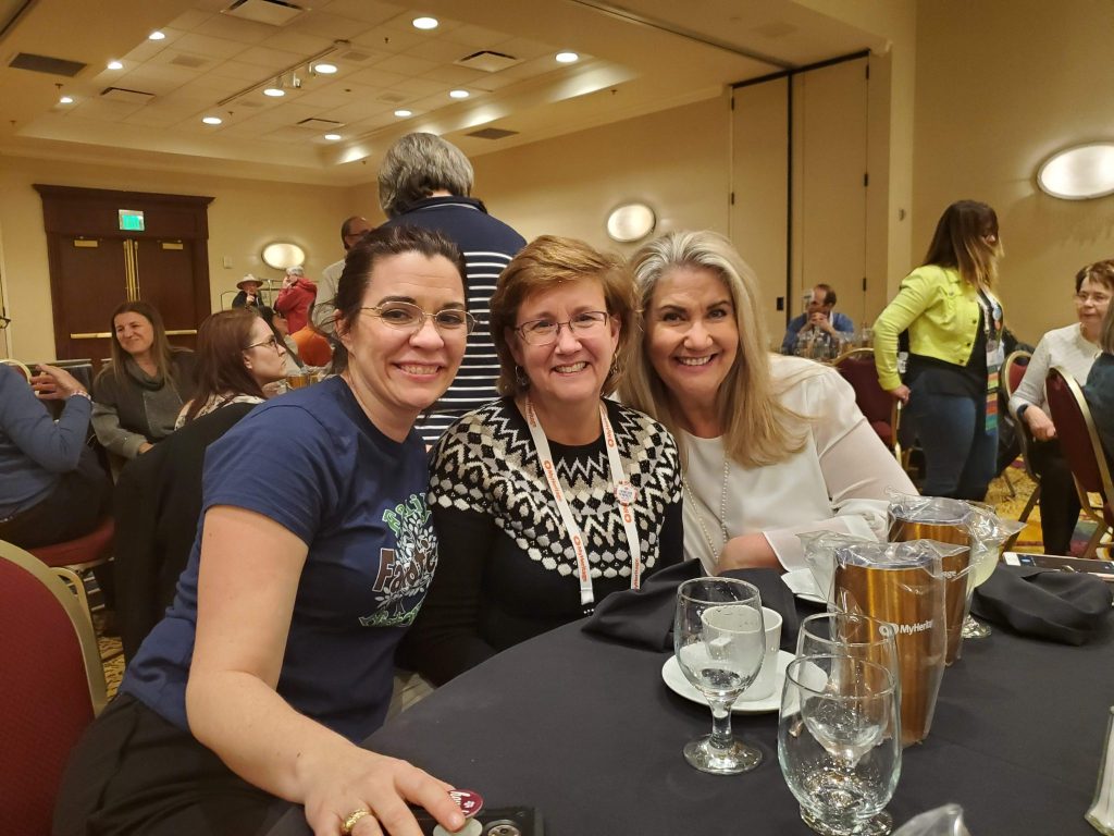 3 women at a dinner smiling together