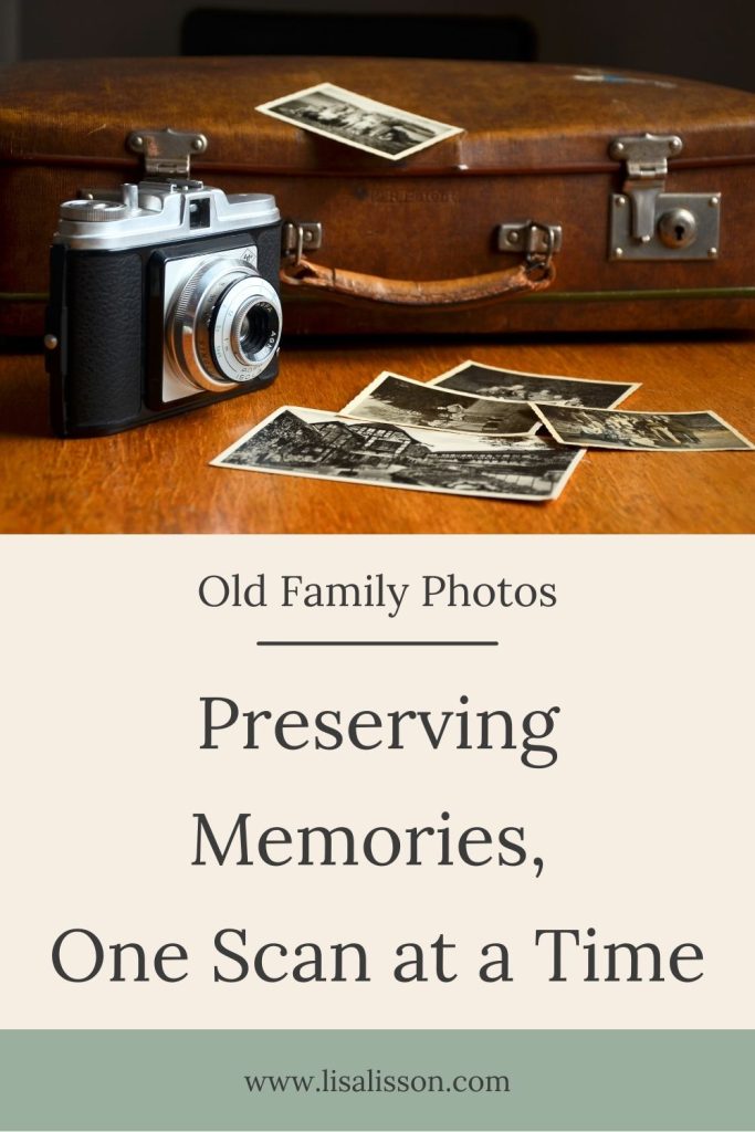 Old suitcase with old camera and a scattering of black and white photos.