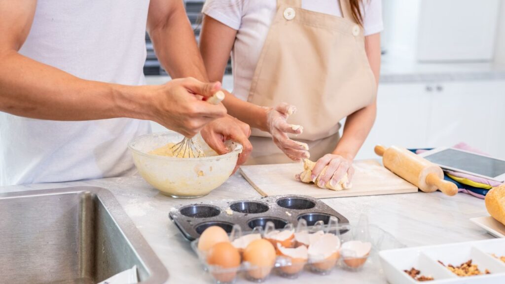 2 people's hands baking in the kitche