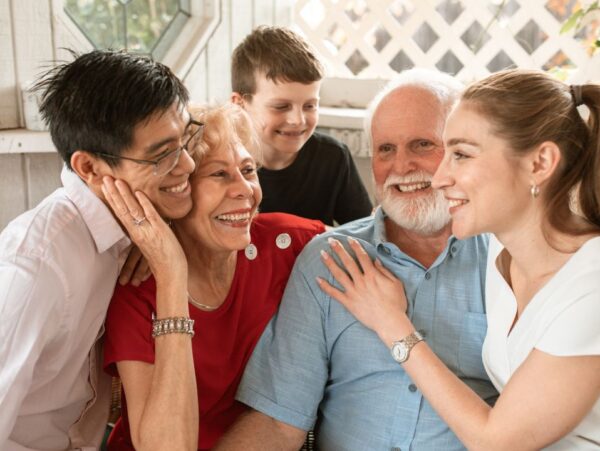 Multigenerational family with grandparents hugging teens
